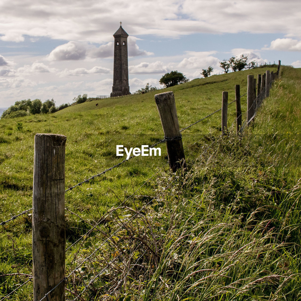 Wooden posts on field against sky