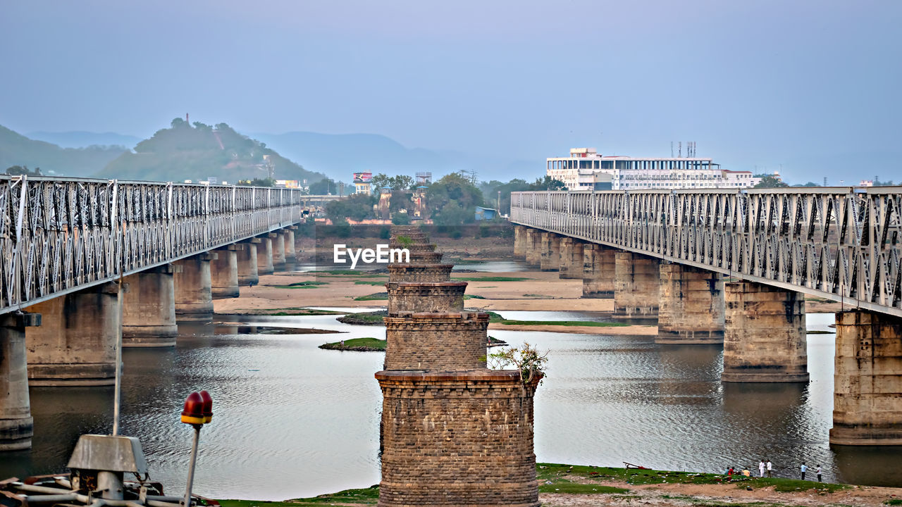 Structure of old bridge and two parallel railway bridges over krishna river in vijayawada, india.