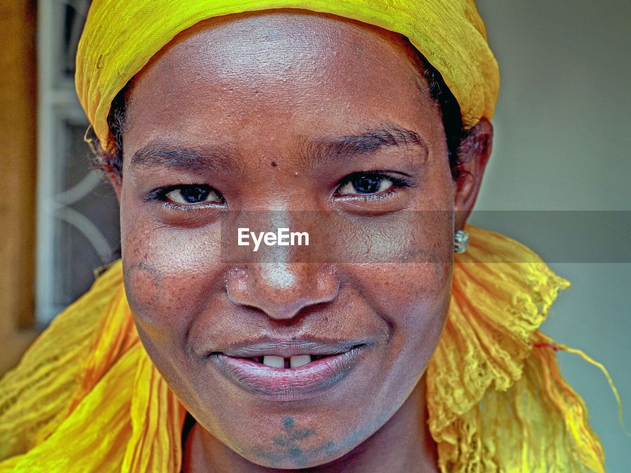 CLOSE-UP PORTRAIT OF A SMILING MAN WITH YELLOW FACE