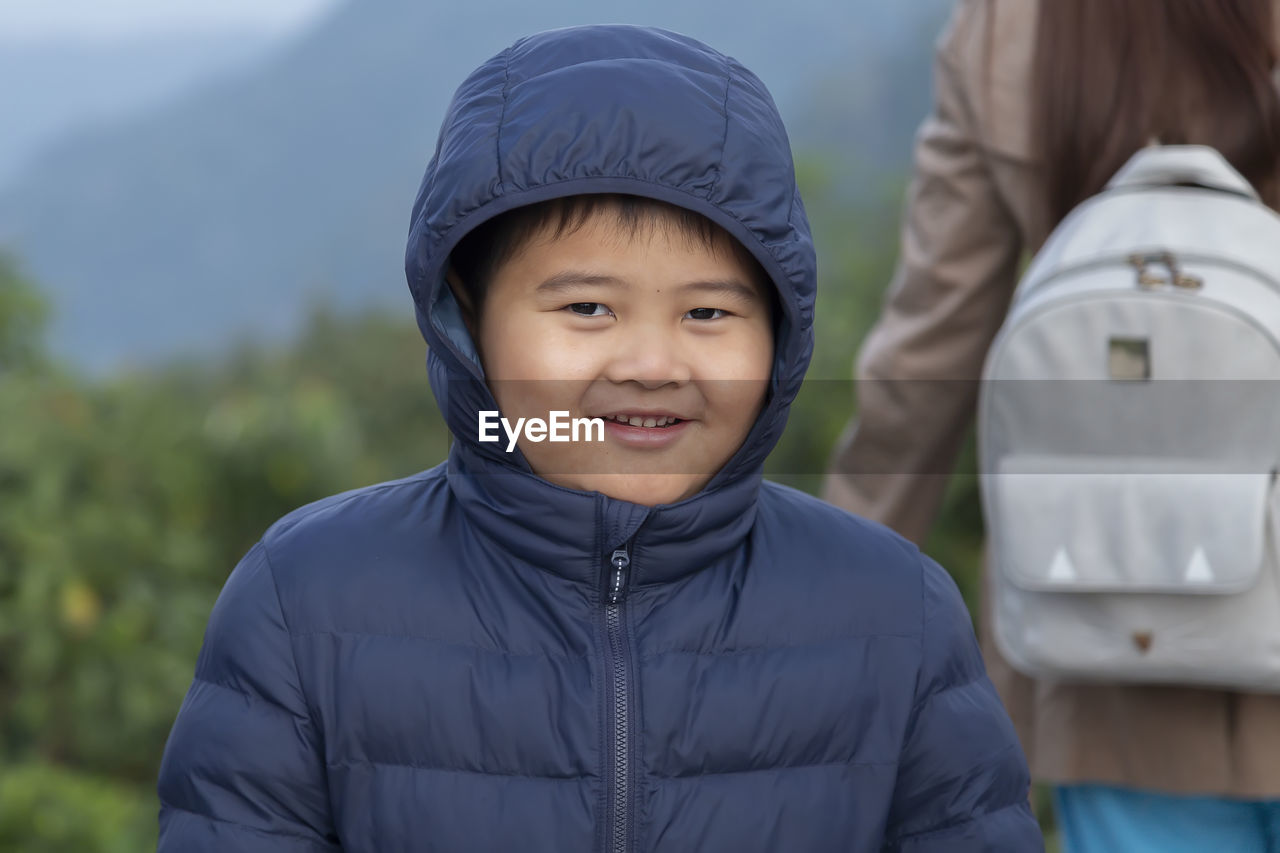 Portrait of smiling boy standing outdoors during winter