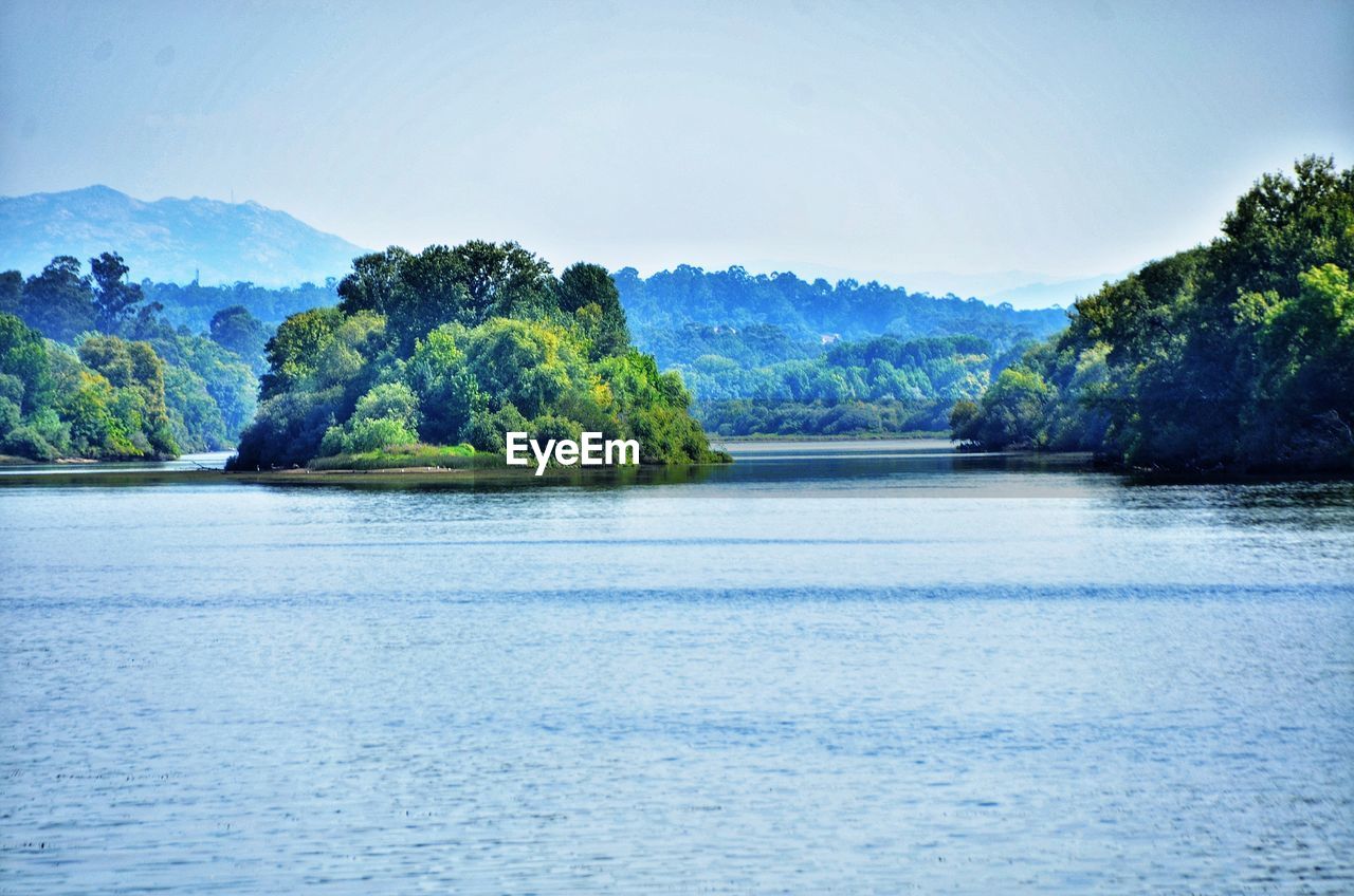 SCENIC VIEW OF LAKE BY TREE MOUNTAINS AGAINST SKY
