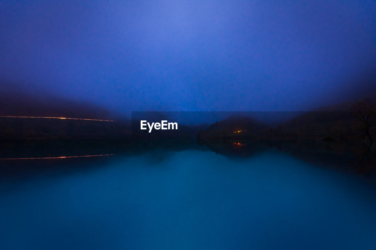 LAKE AGAINST SKY AT NIGHT