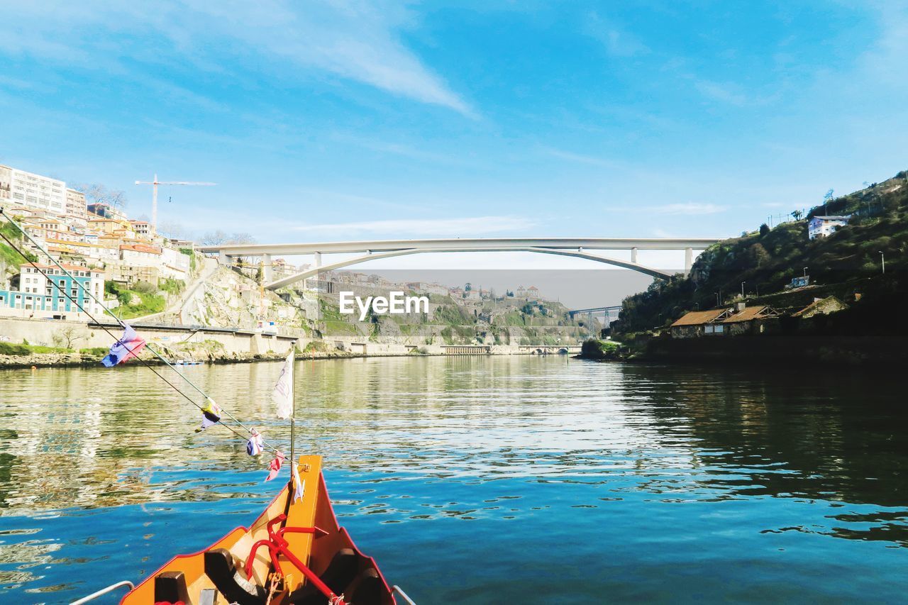 BRIDGE OVER RIVER AGAINST BLUE SKY