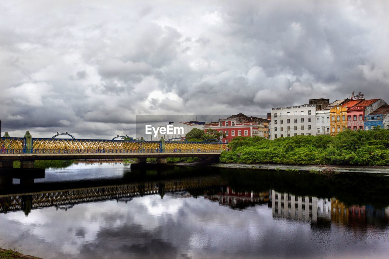 River in town against cloudy sky