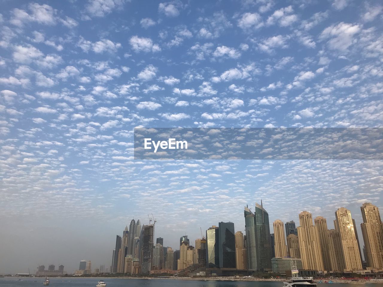 Buildings in city against cloudy sky