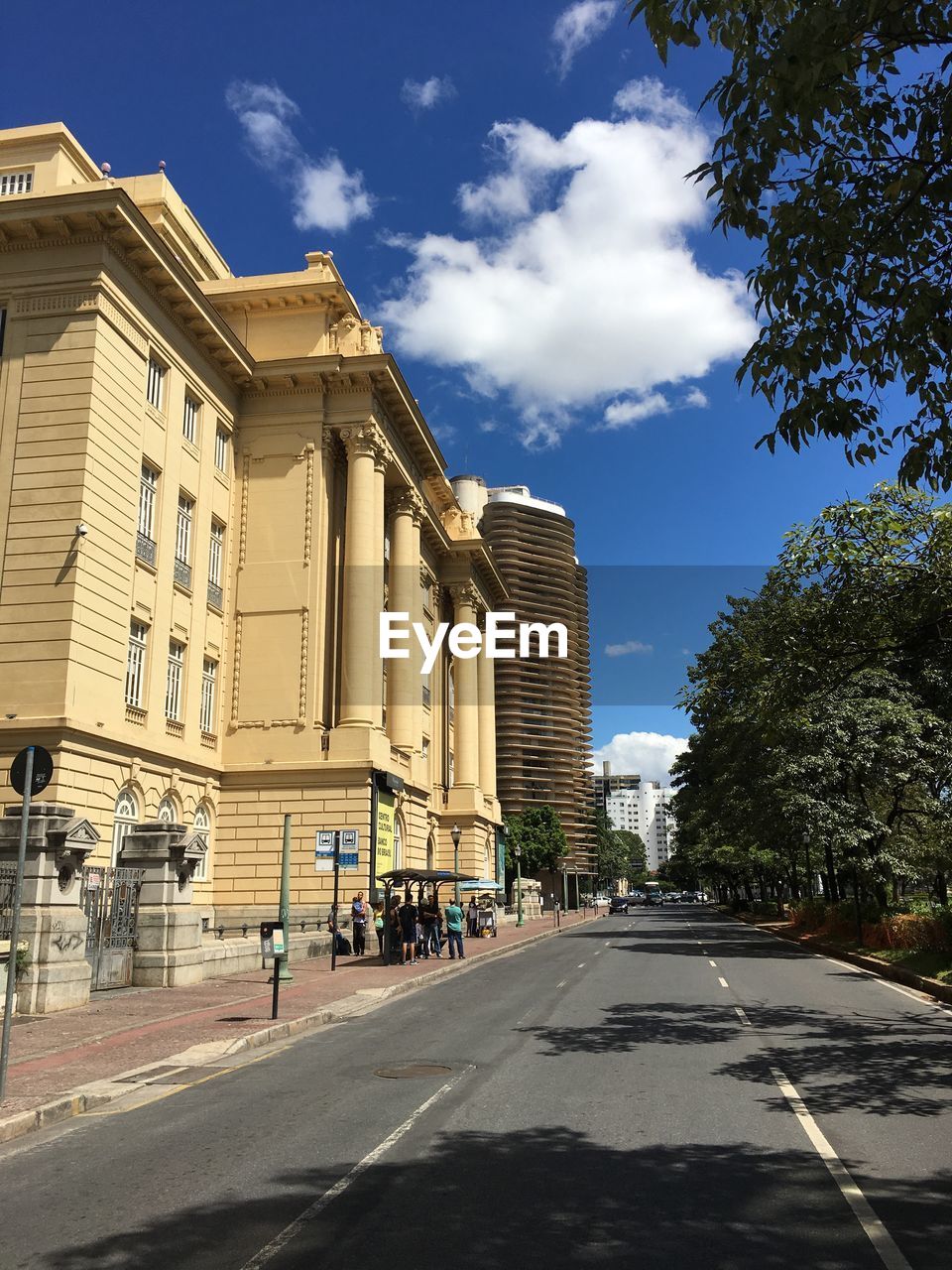 Road by buildings in city against sky