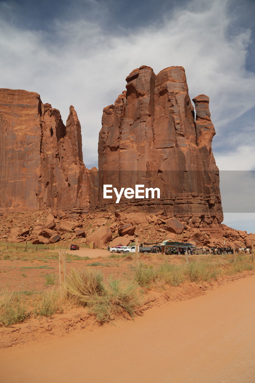 Rock formations on landscape against cloudy sky