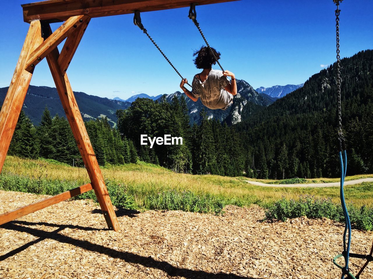 Woman swinging with mountains in background