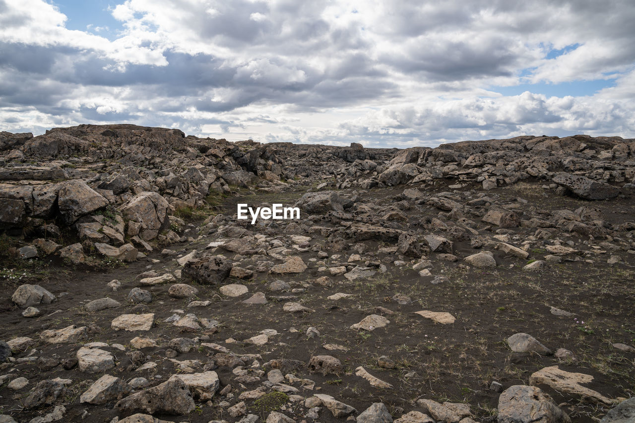 ROCKS ON LAND AGAINST SKY