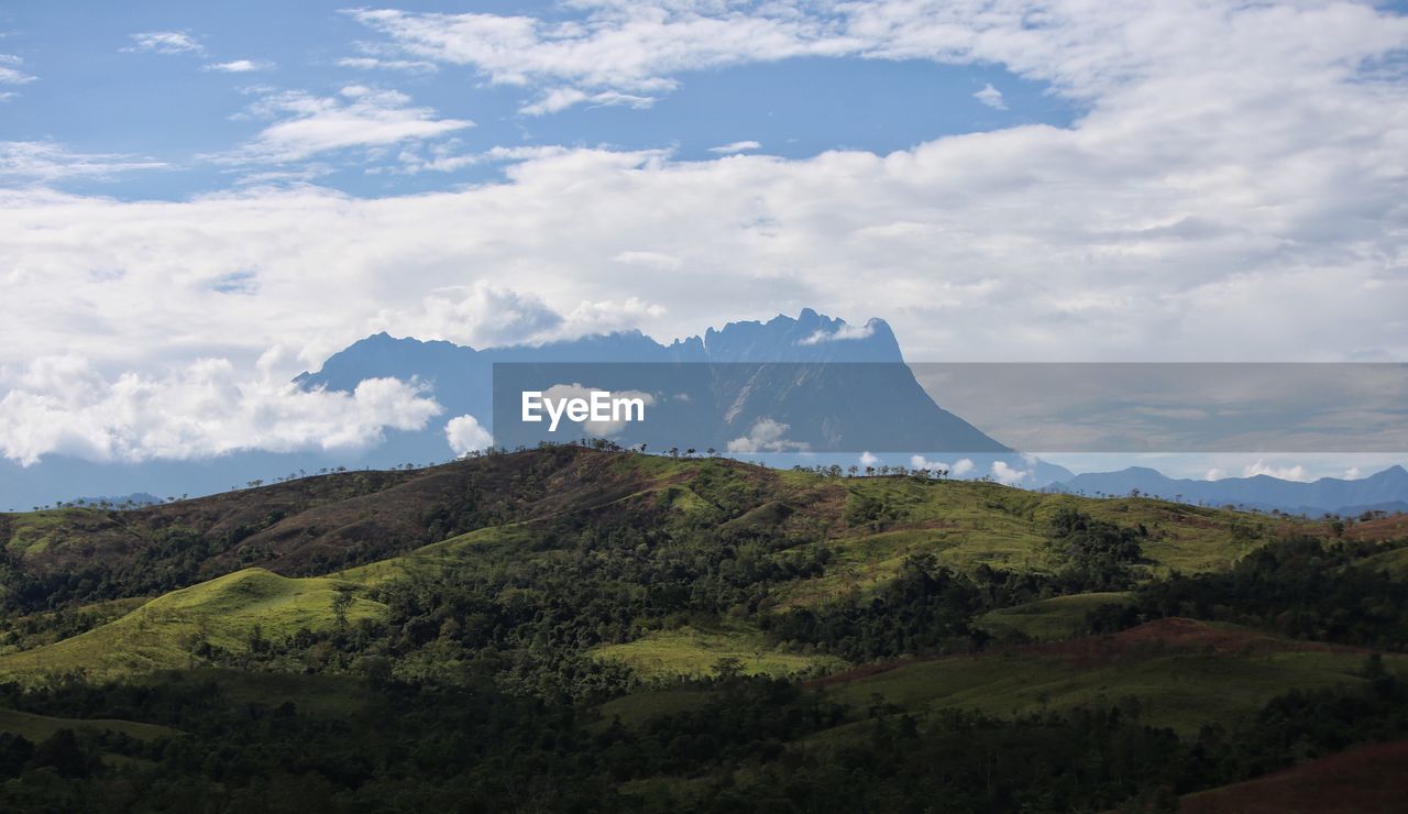 Scenic view of mountains against cloudy sky