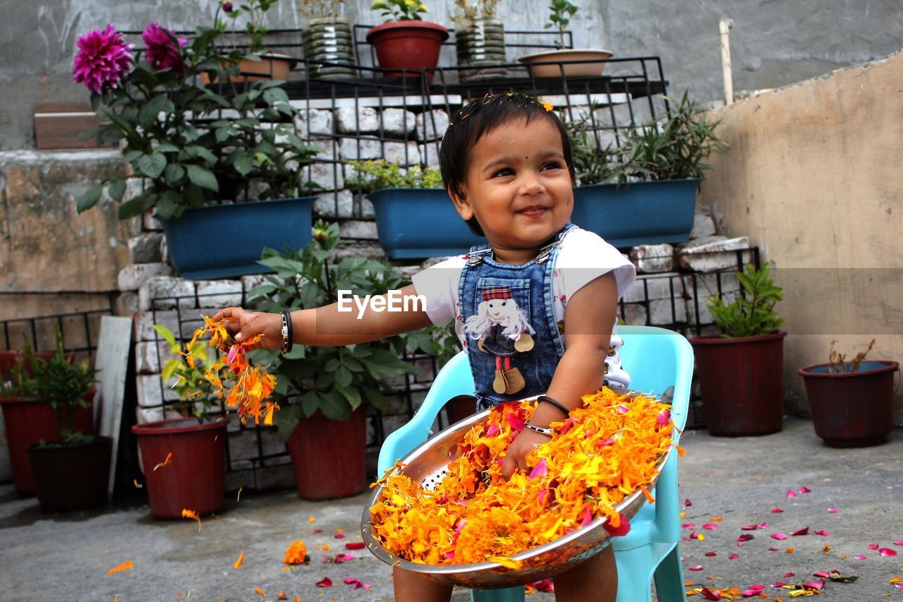 Portrait of cute boy in flower pot