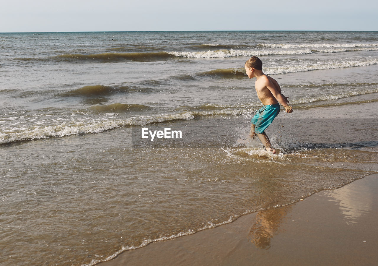 REAR VIEW OF PEOPLE ON BEACH