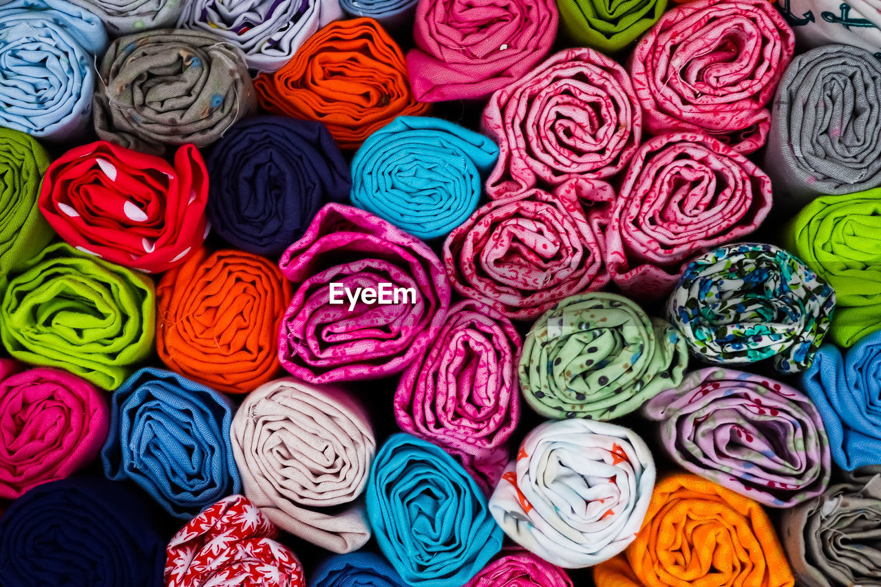 Close up view on samples of cloth and fabrics in different colors found at a fabrics market.