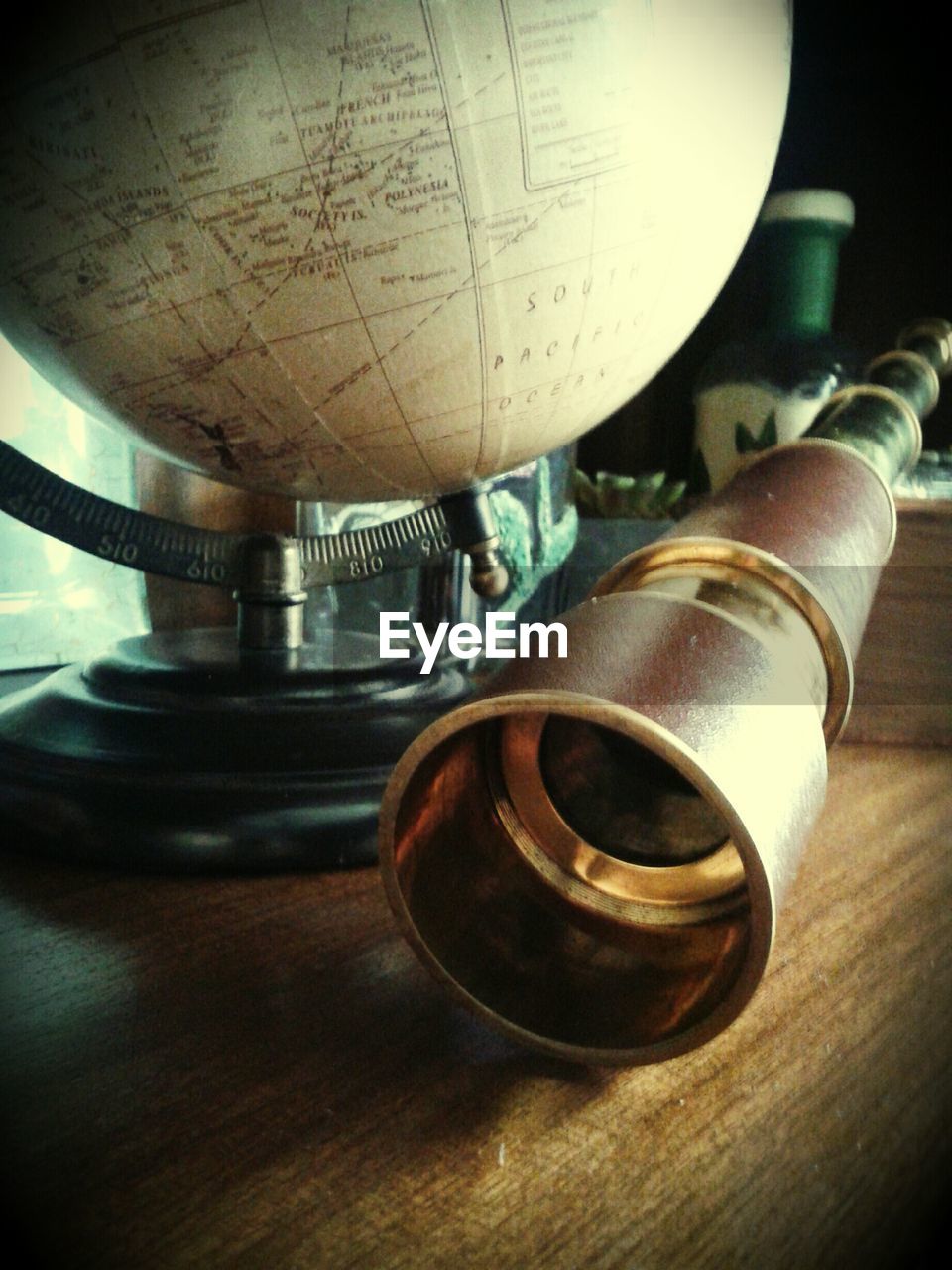 Close-up of binoculars and globe on table