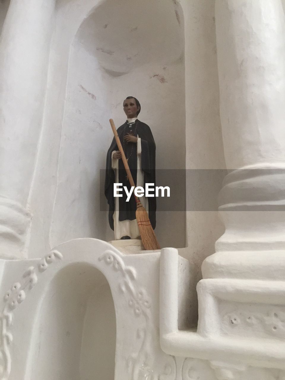 CLOSE-UP OF STATUE AGAINST MAN STANDING IN SCULPTURE