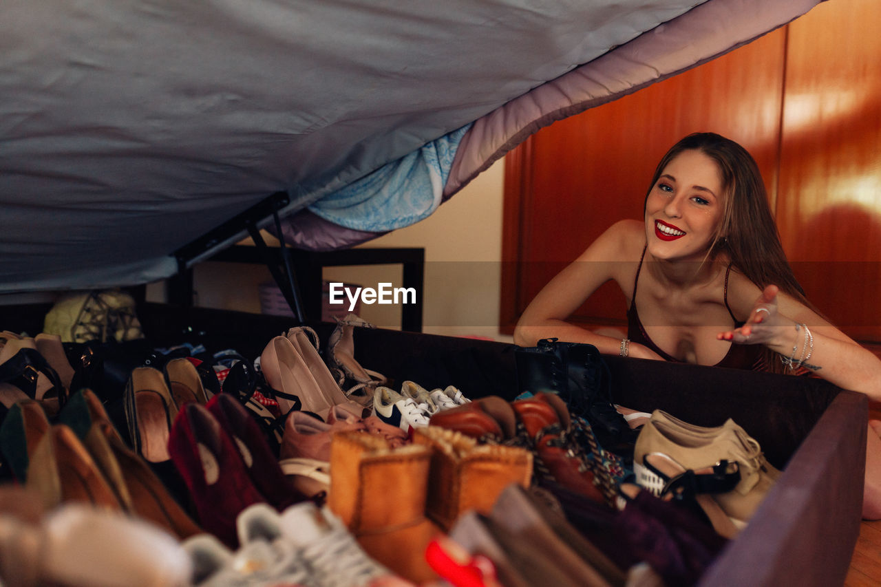 Teenager showing off her large collection of shoes, sneakers and heels.