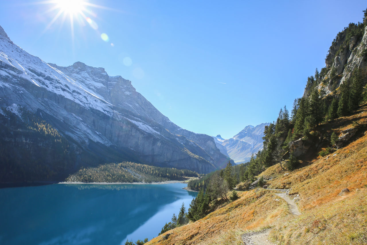 Scenic view of lake and mountains against blue sky