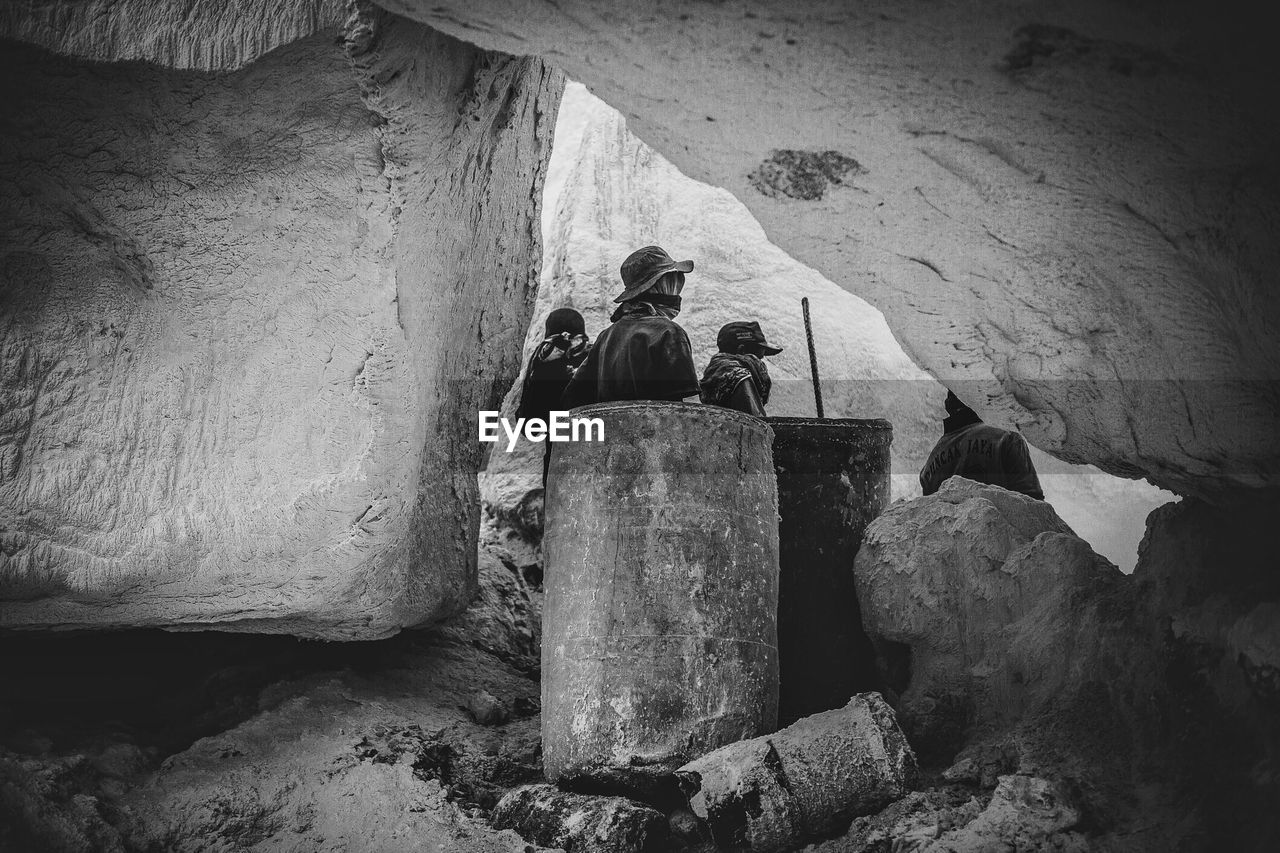 Workers seen through rocks