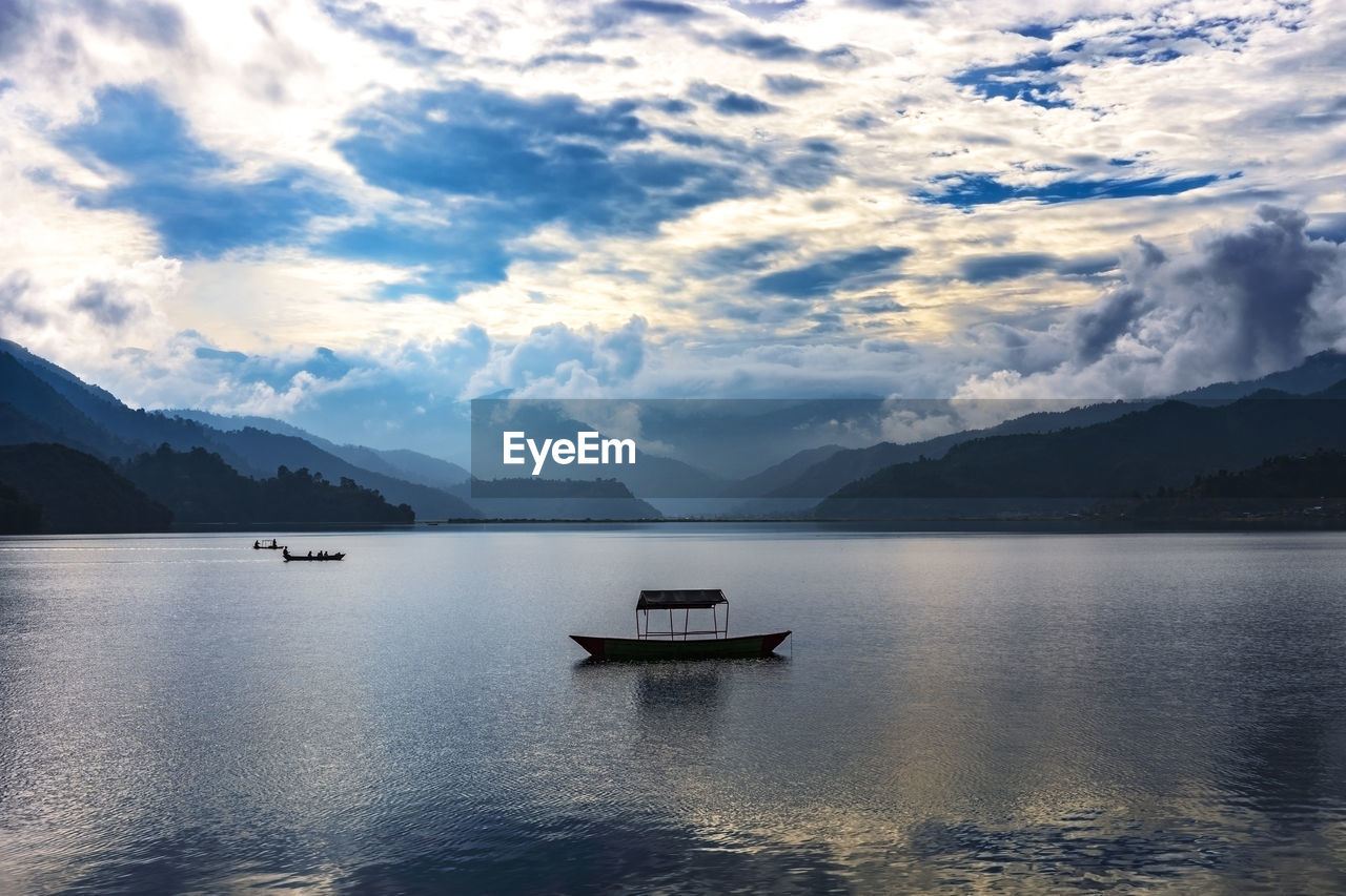 SCENIC VIEW OF LAKE AGAINST CLOUDY SKY