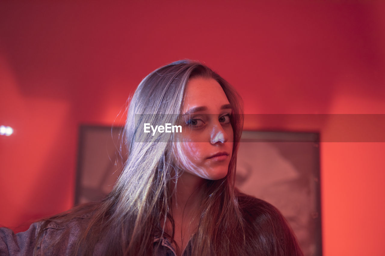 Portrait of beautiful woman against picture frame and wall