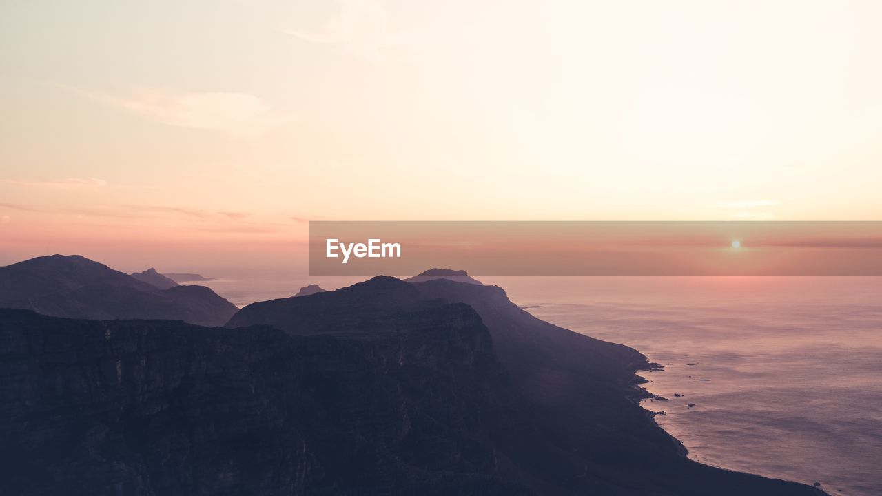 Scenic view of sea and mountains during sunset