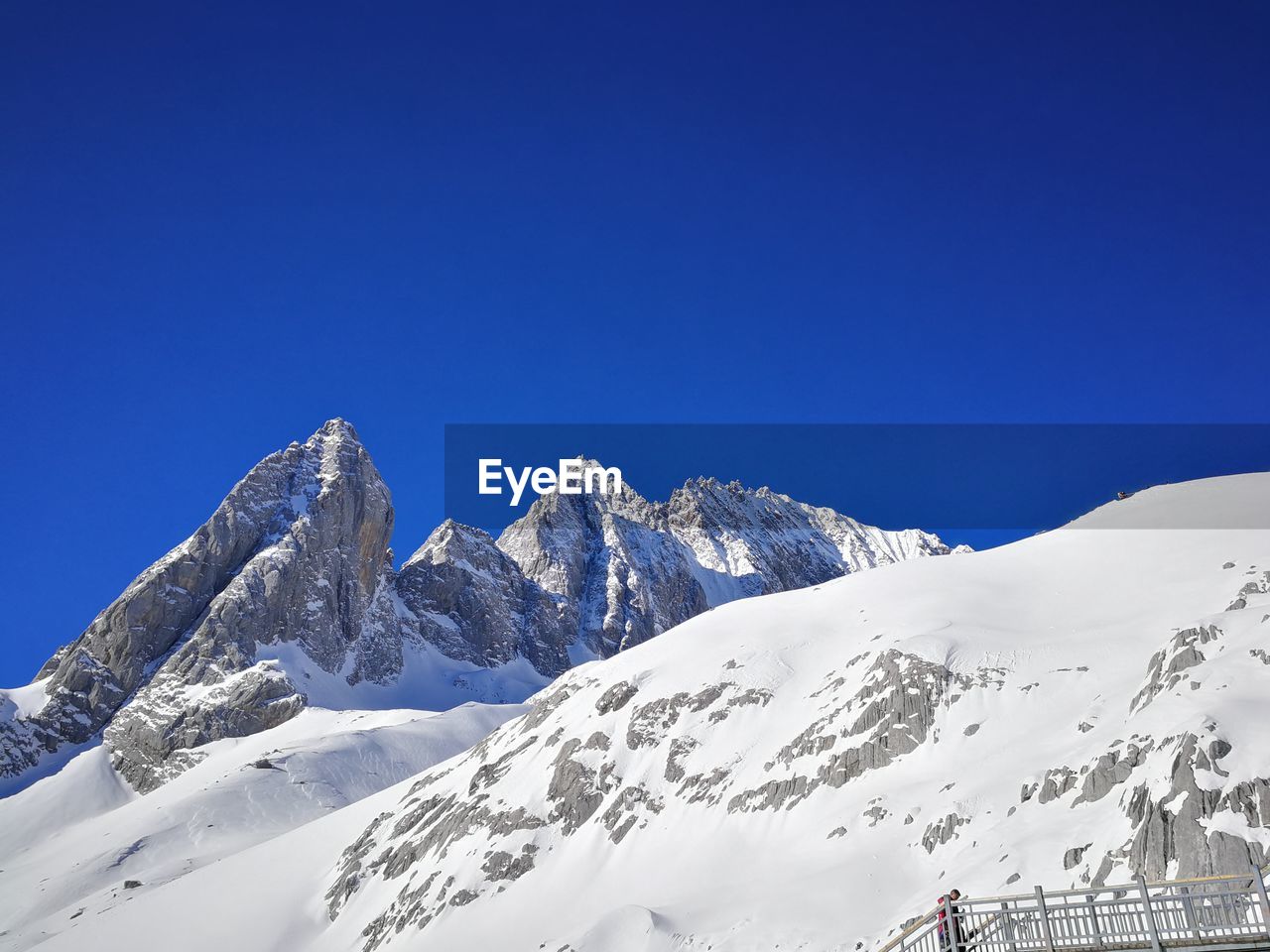 Scenic view of snowcapped mountains against clear blue sky