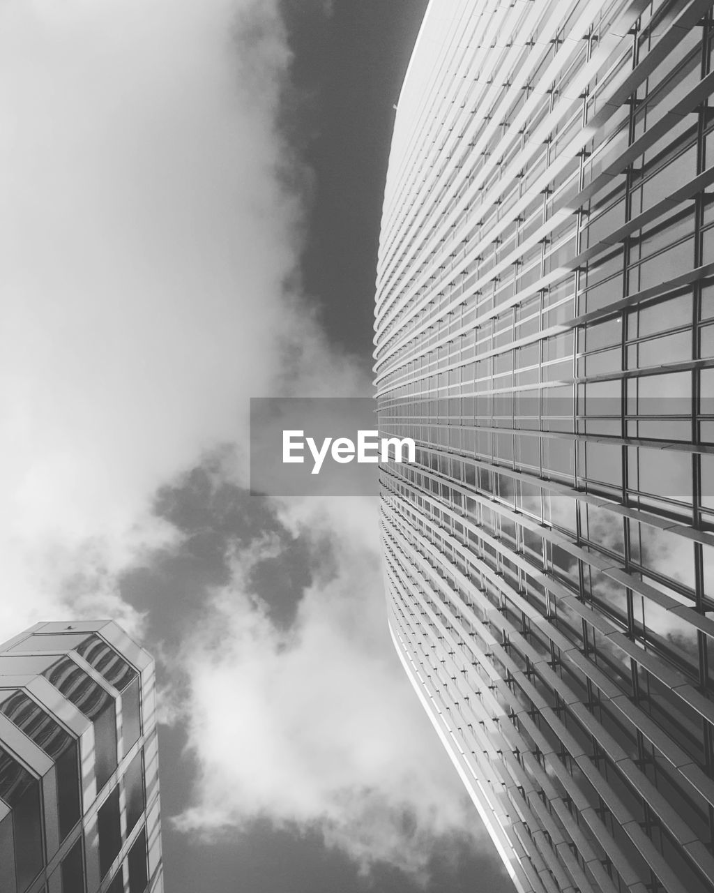 Low angle view of modern building against cloudy sky