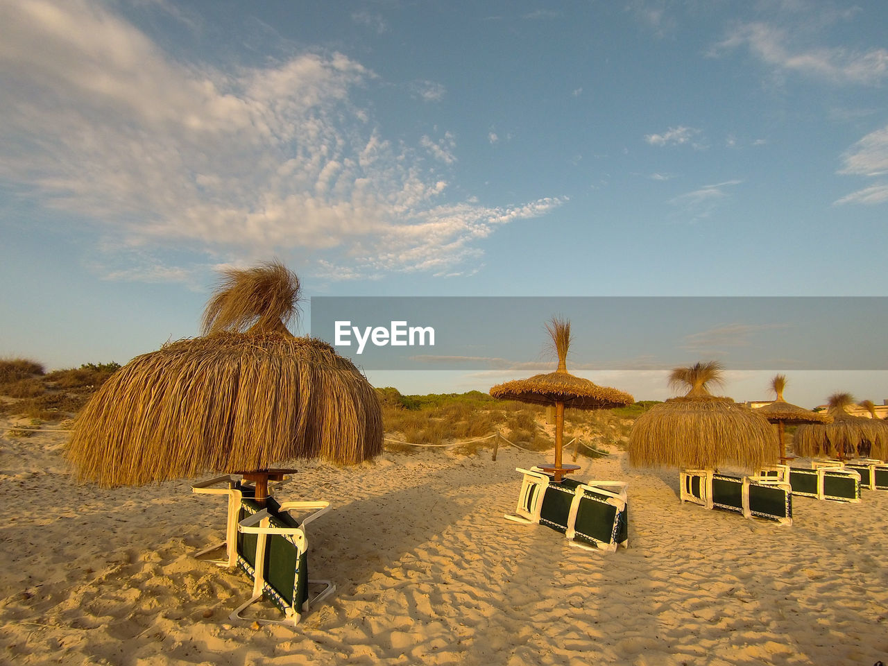 sky, land, natural environment, sand, nature, landscape, cloud, environment, scenics - nature, chair, thatched roof, beach, sunlight, beauty in nature, desert, tranquility, travel, travel destinations, sea, tranquil scene, summer, outdoors, holiday, vacation, parasol, no people, seat, day, trip