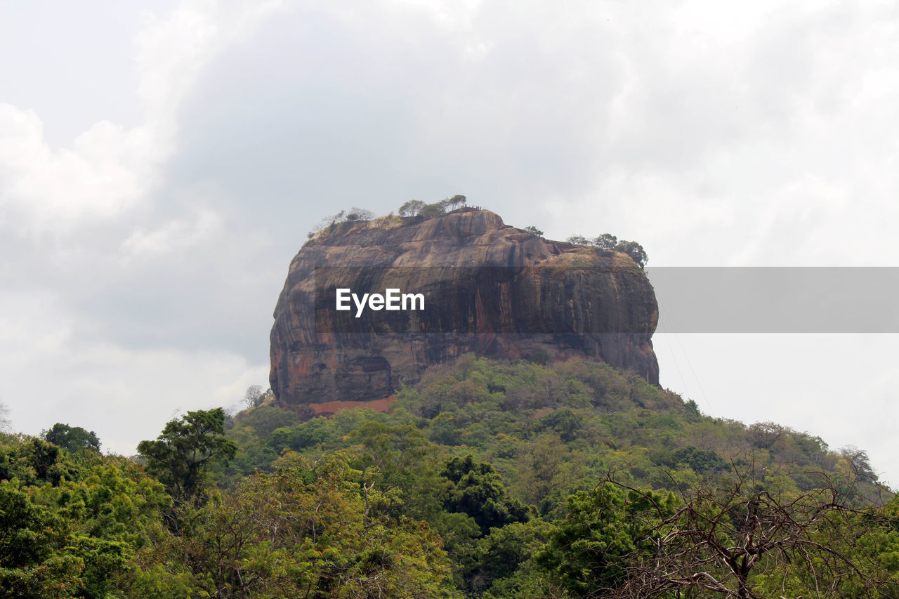 LOW ANGLE VIEW OF ROCKS ON MOUNTAIN AGAINST SKY