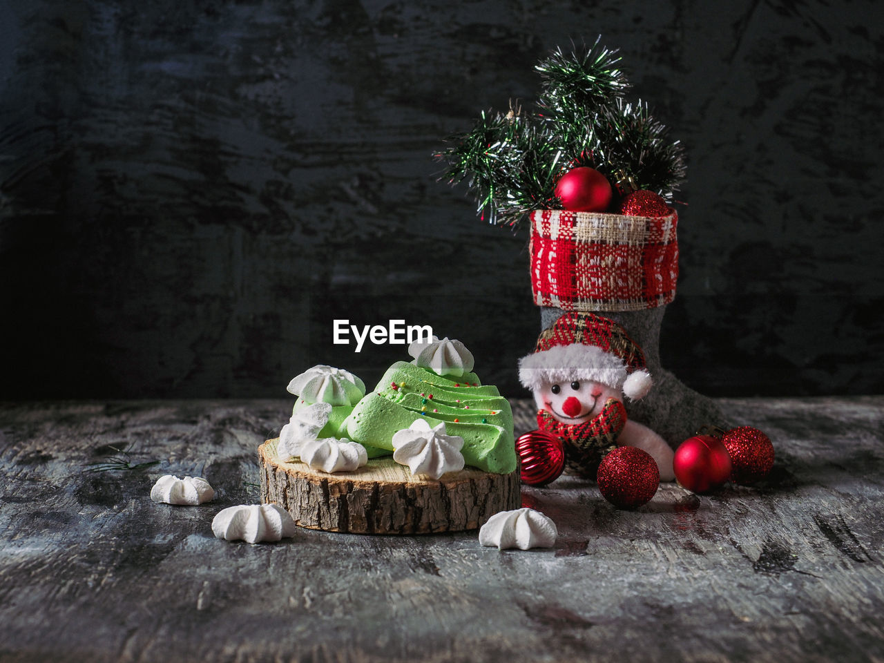 Christmas boot with red balls and tinsel, and festive meringue cookies 