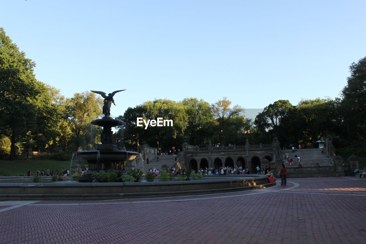 Bethesda fountain by historic building at central park against clear sky