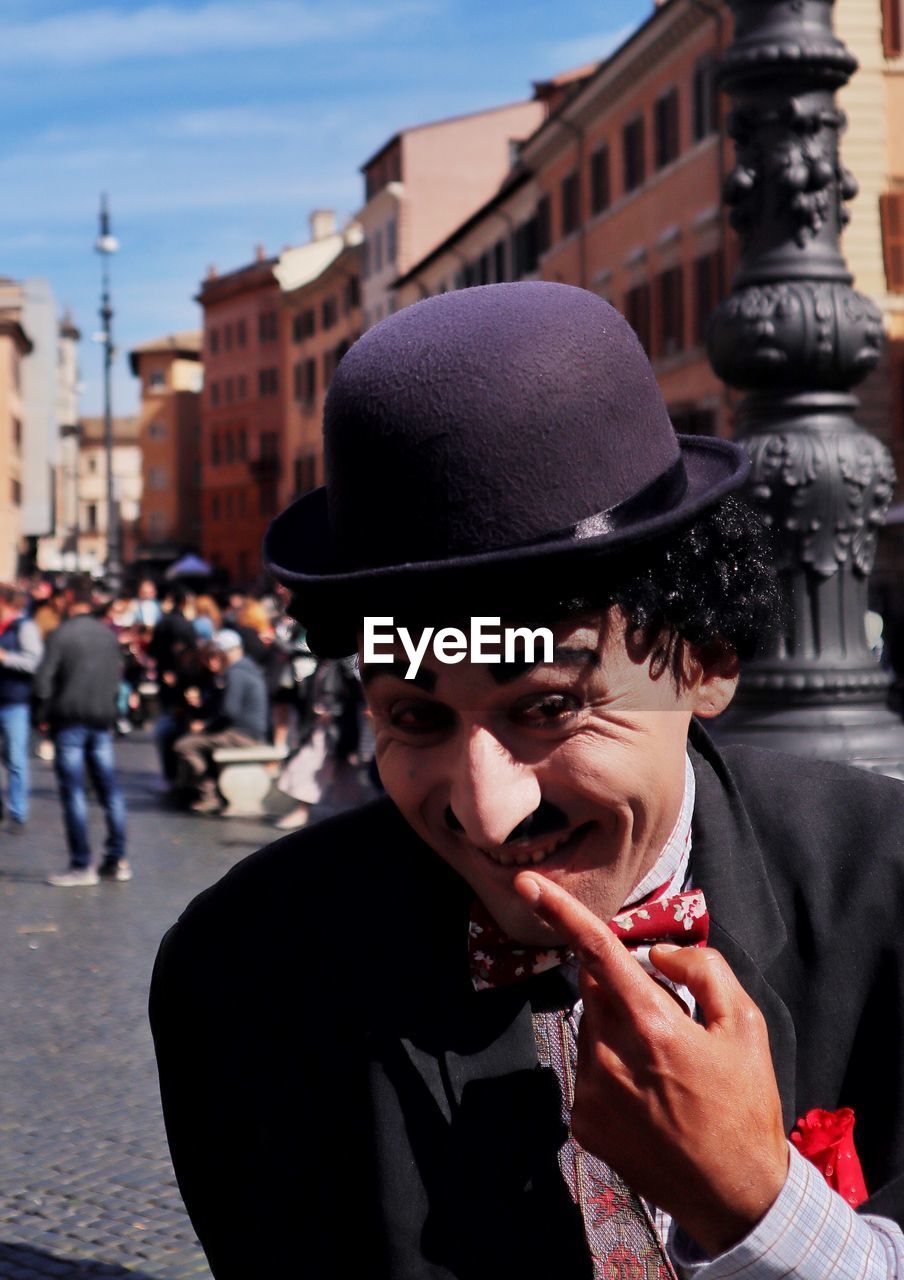 Portrait of smiling man with hat on street in city