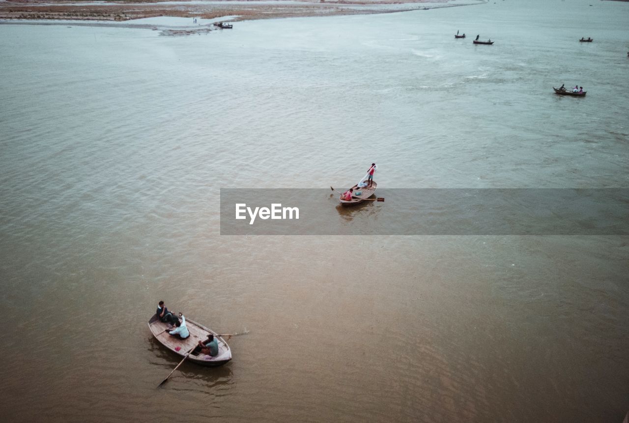 HIGH ANGLE VIEW OF PEOPLE SAILING ON SEA