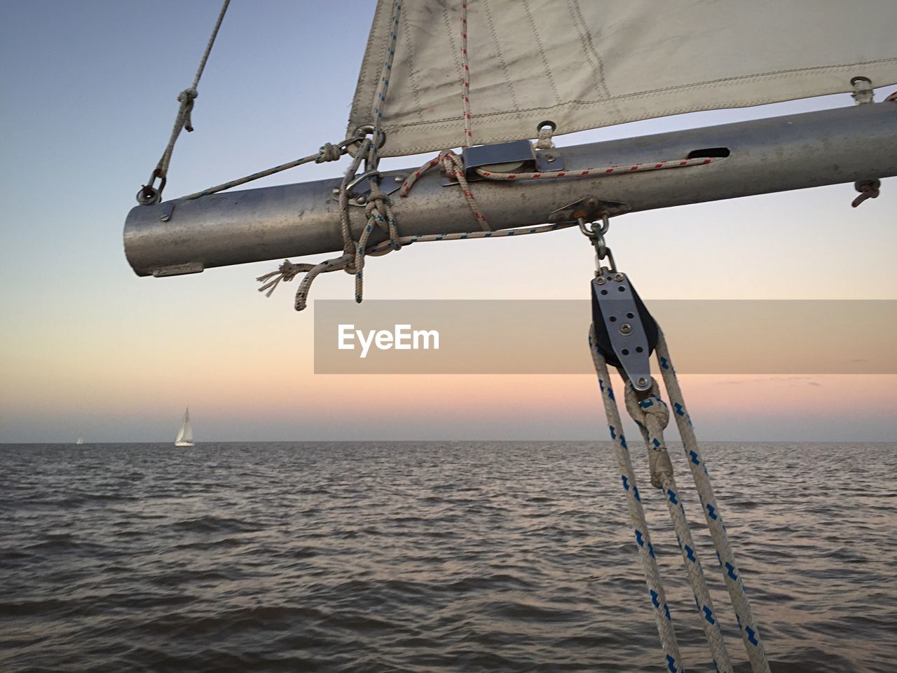 Sailboat at sea against sky during sunset