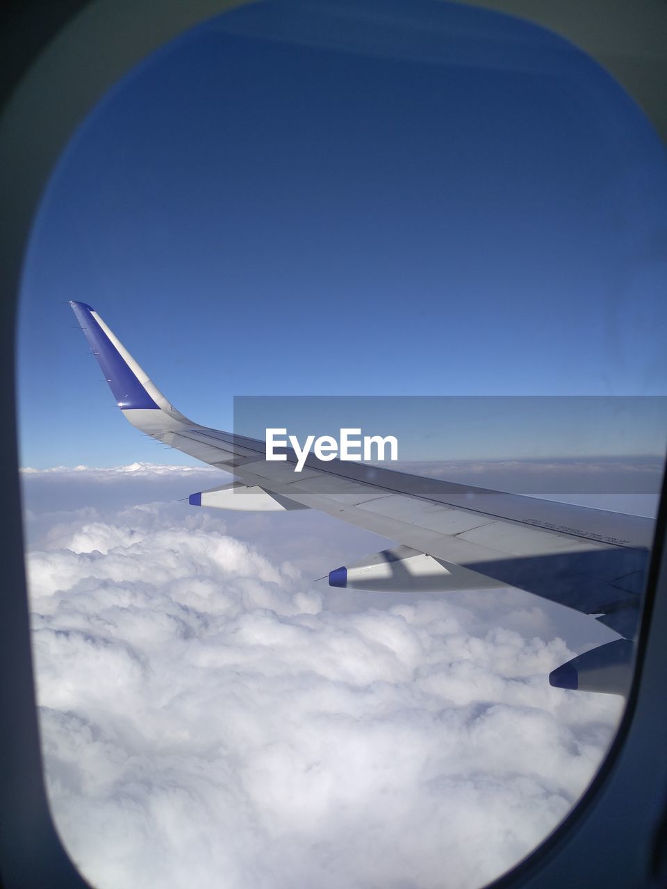 CROPPED IMAGE OF AIRPLANE WING OVER LANDSCAPE