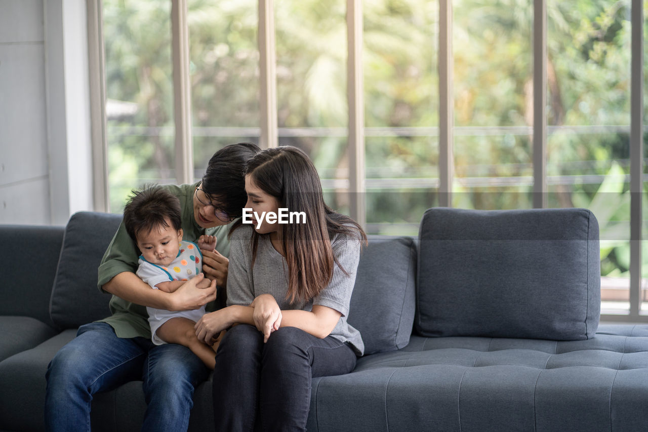 FRIENDS SITTING ON SOFA AT HOME