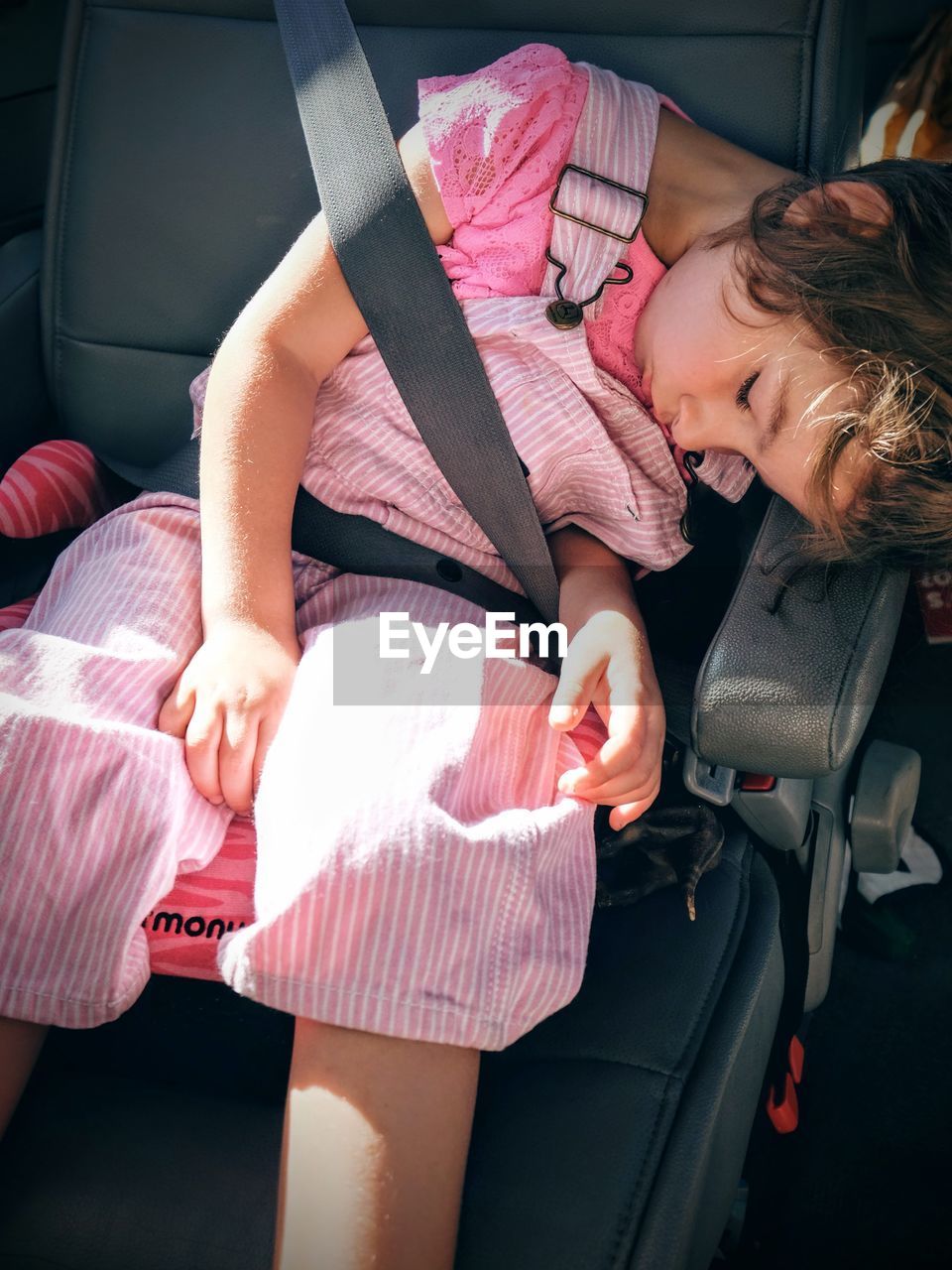 High angle view of girl sleeping on car seat