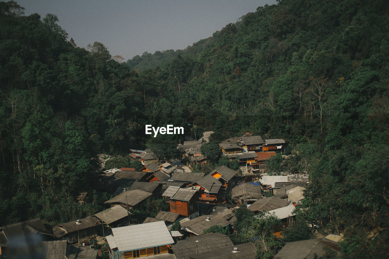 High angle view of houses and trees by mountains