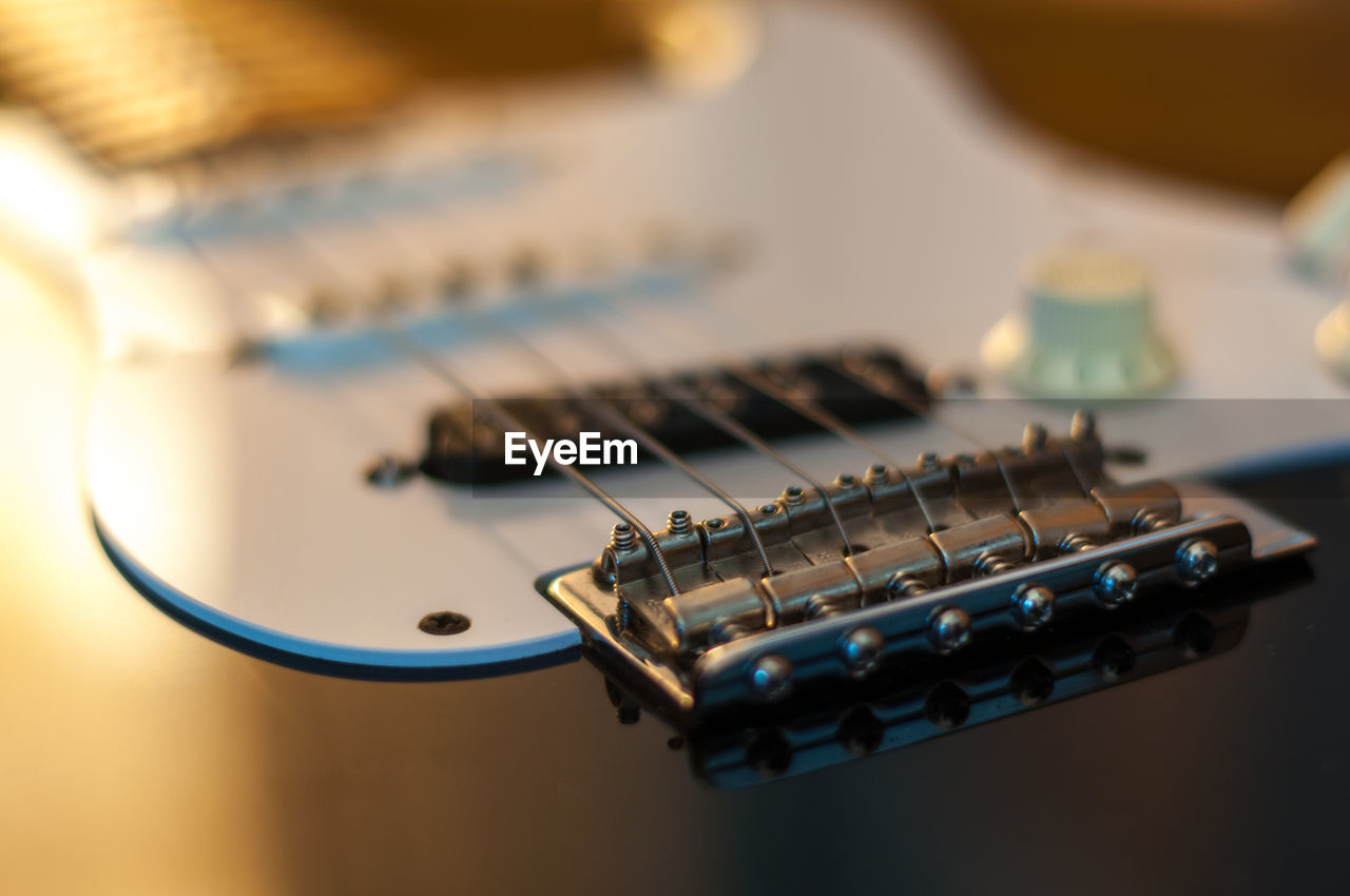 CLOSE-UP OF GUITAR ON TABLE AT HOME