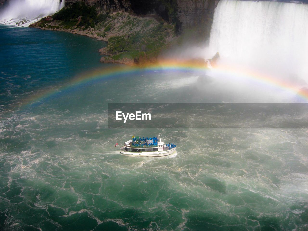 Scenic view rainbow over ferry boat in niagara falls