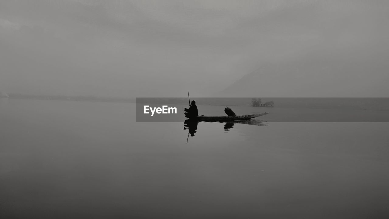 Silhouette boat in sea against sky