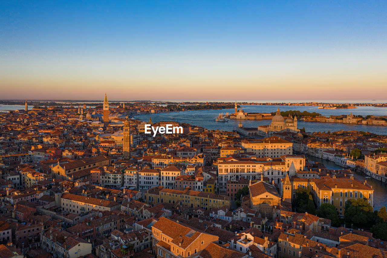 HIGH ANGLE SHOT OF TOWNSCAPE AGAINST SKY DURING SUNSET