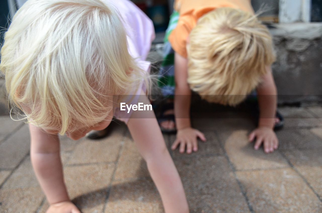 Close-up of siblings playing on street