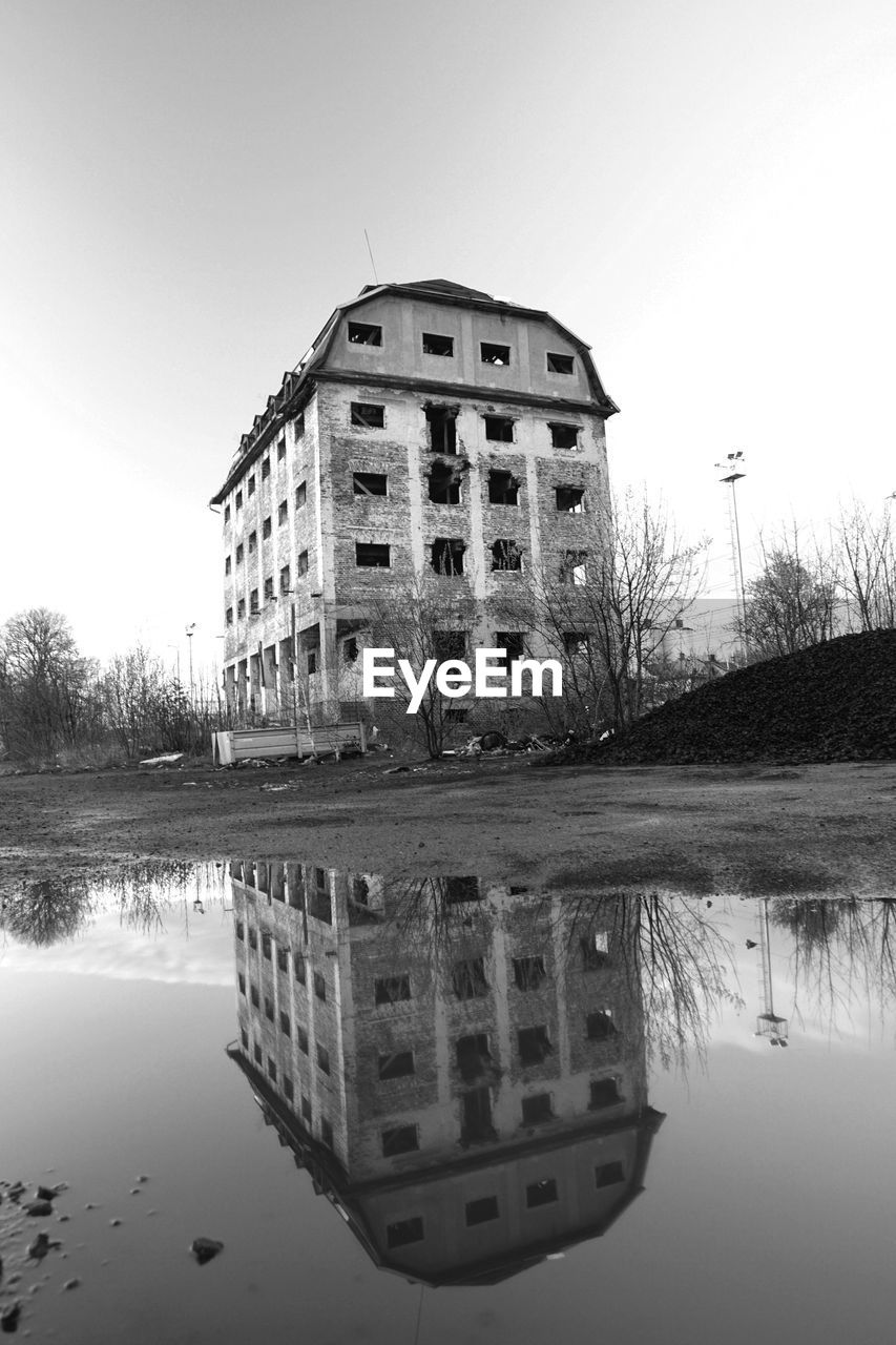 Reflection of building in lake against sky