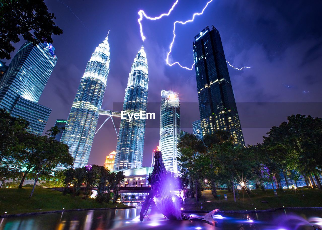 Low angle view of illuminated buildings against sky at night