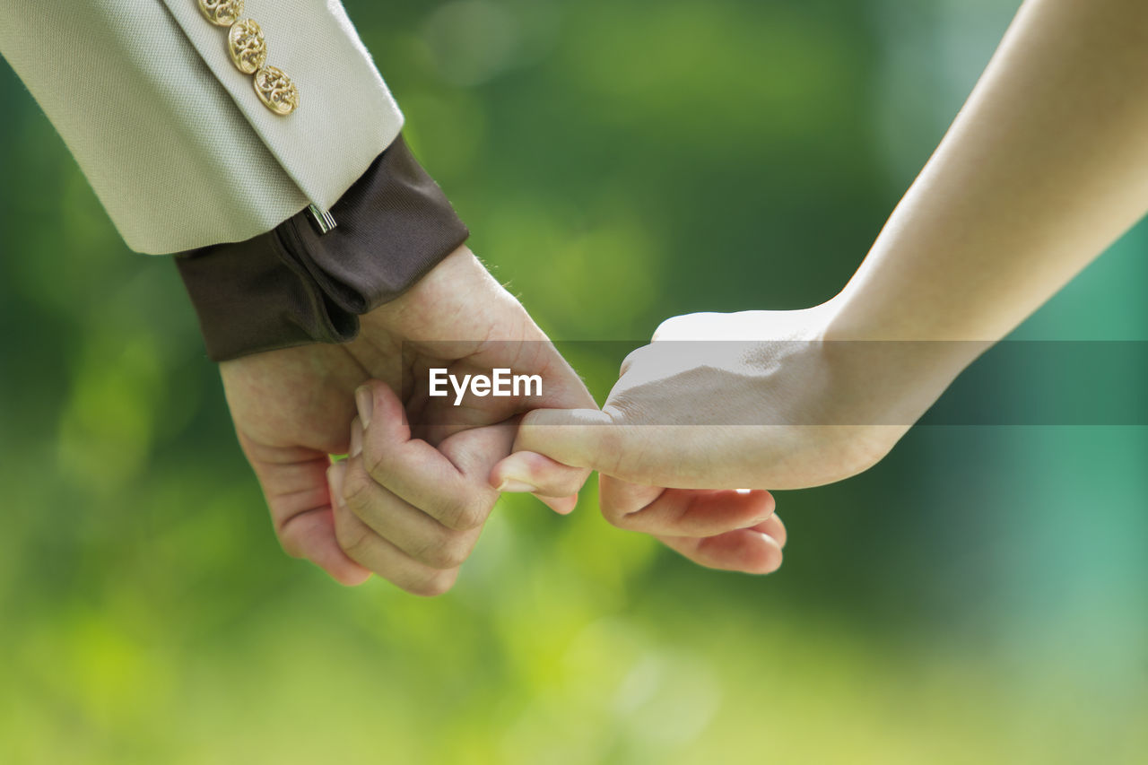 Cropped image of couple holding hands