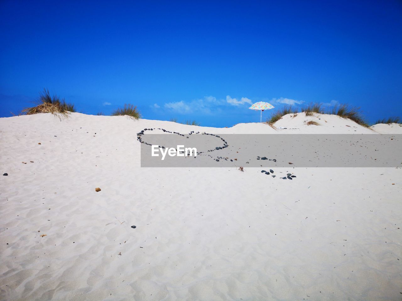 Scenic view of beach against clear blue sky