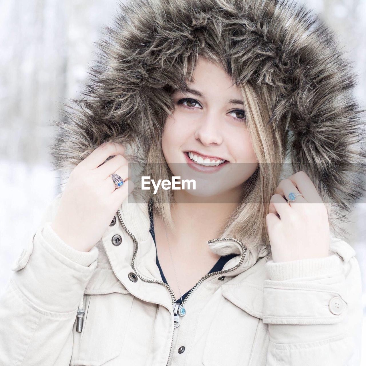 PORTRAIT OF SMILING YOUNG WOMAN WITH SNOW IN MOUTH