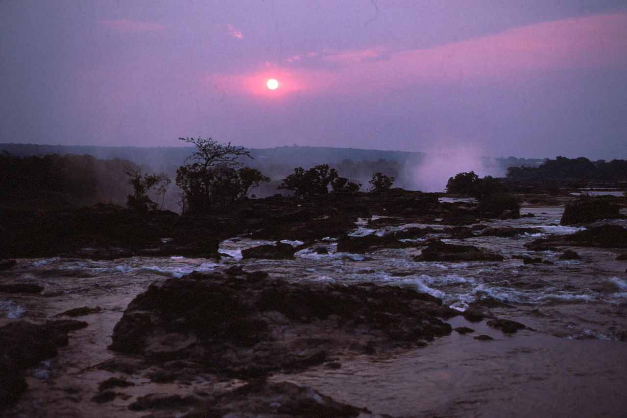 Scenic view of river with rock formations at sunset