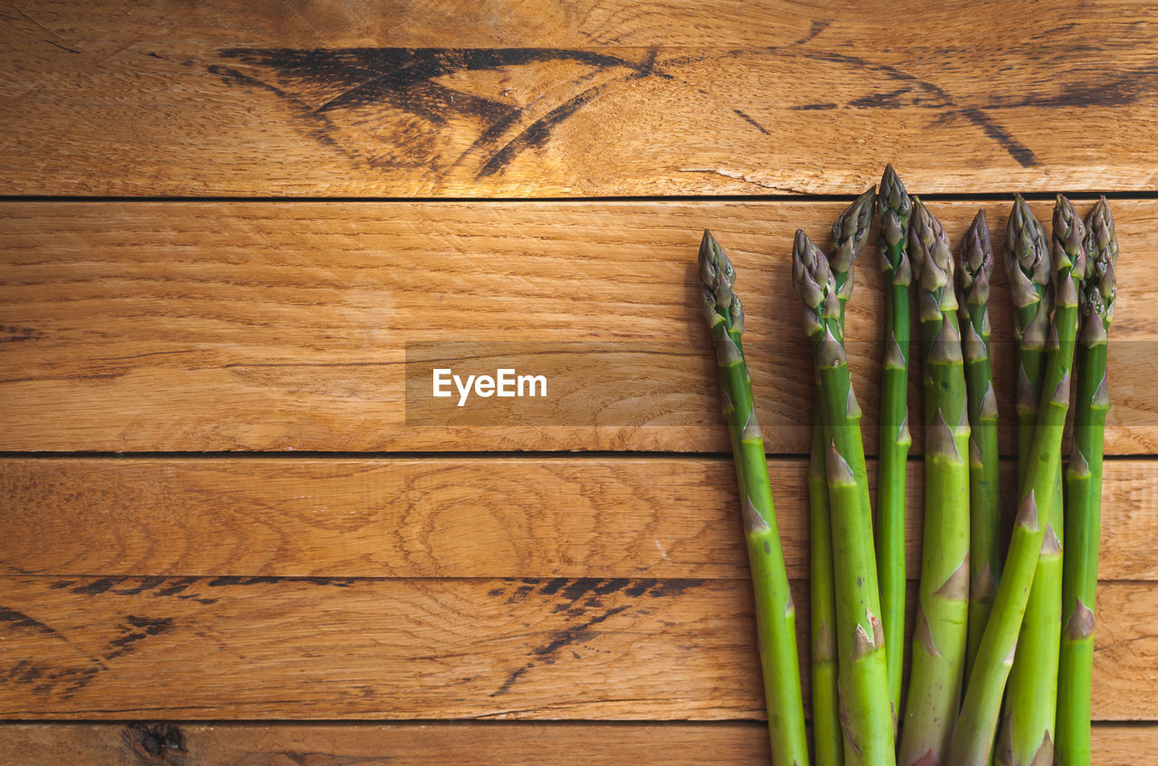 Fresh green asparagus on wooden background, top view, text space, copy space